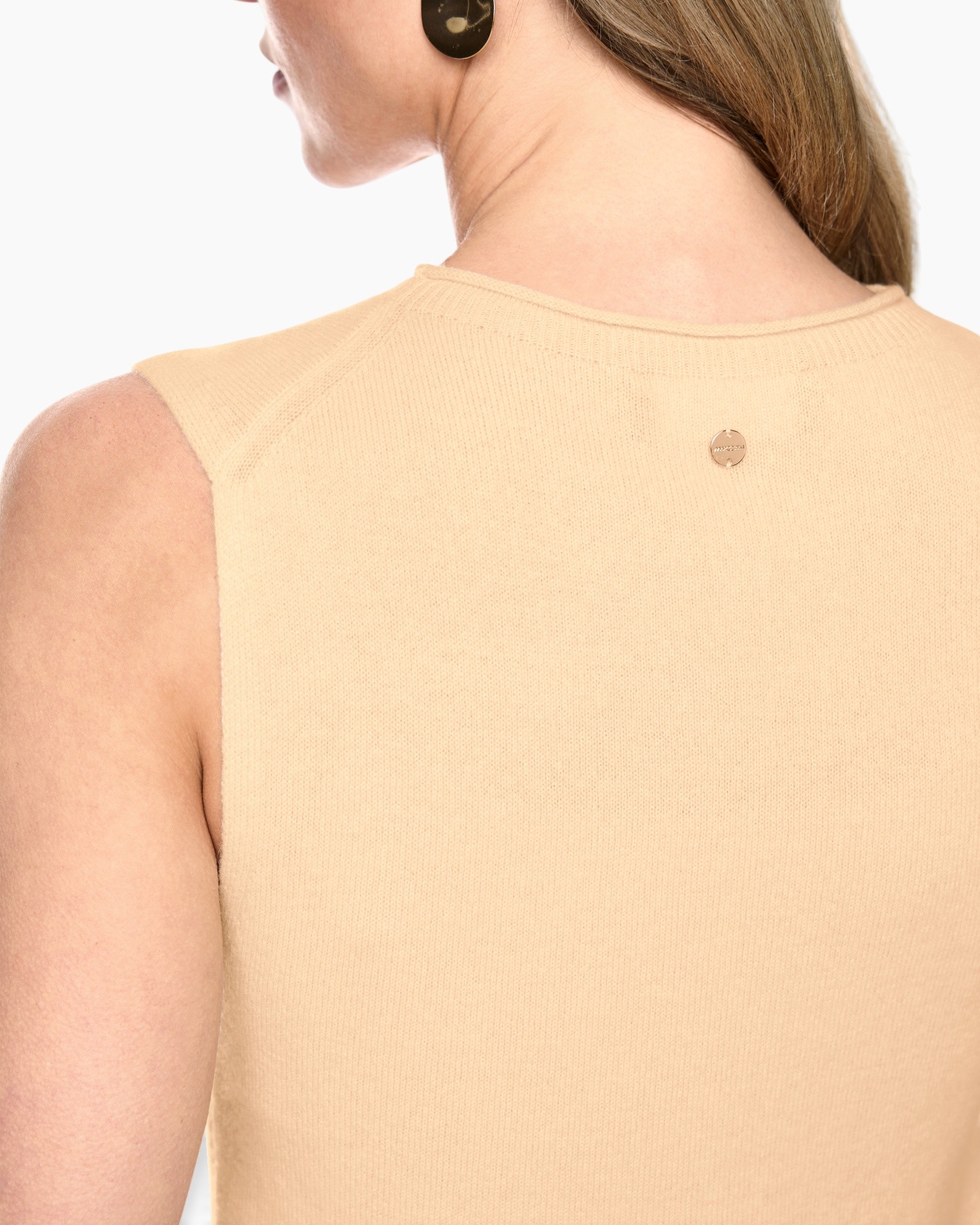 mouwloos top, beige breisel, rugst detail, kleine metalen badge, zachte stof