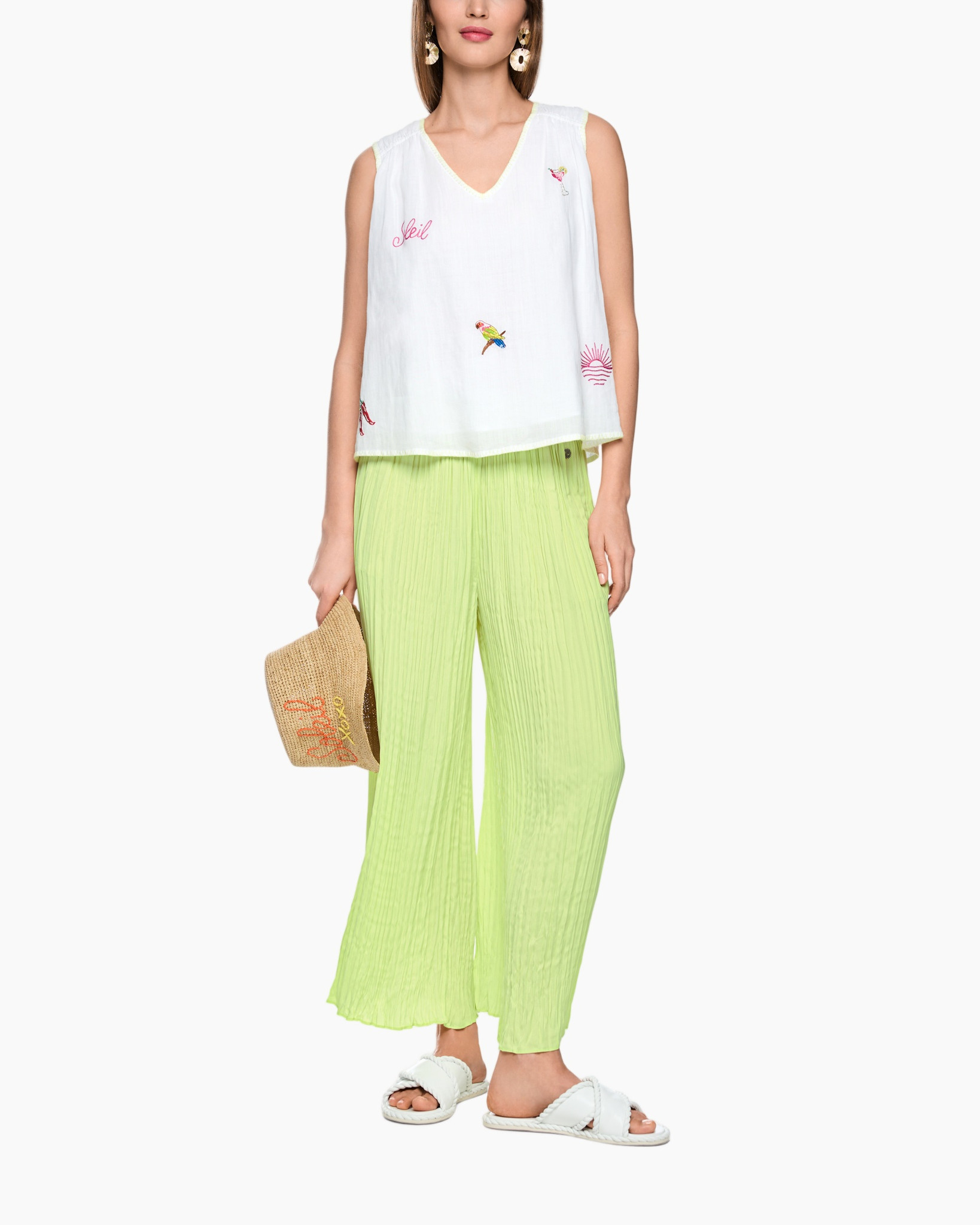 wit he mouwloze top, borduursel, lime groene broeken, plooien, platte sandalen