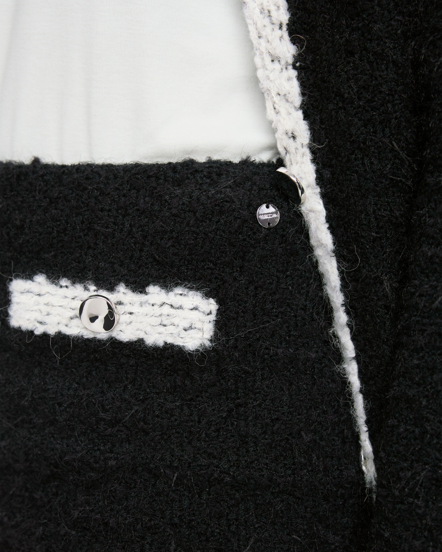 zwarte pak, bouclé, witte rand, metalen knopen, zakdetail