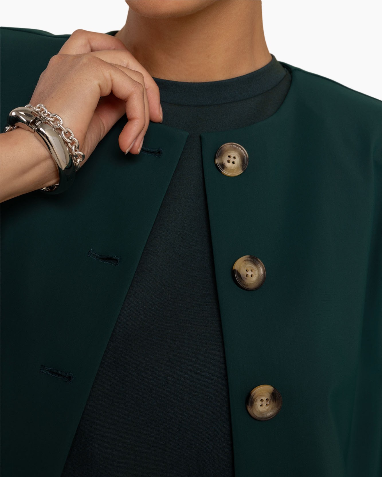 groene jas, knopen detail, knopenrij, donkere kleur, mouwloze jas