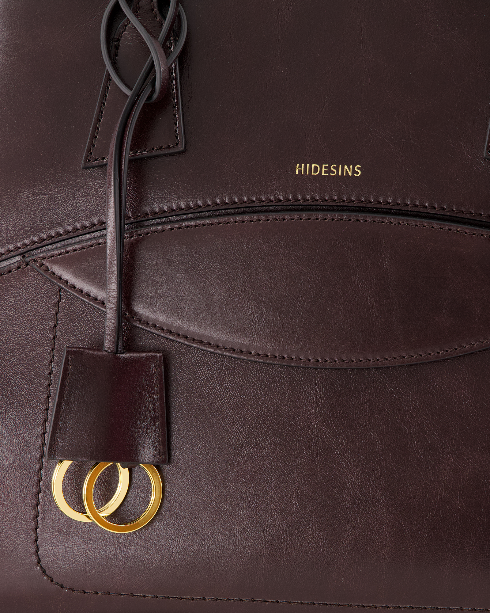 leren tas, bruin, gouden ringen, stiksels, merknaam label