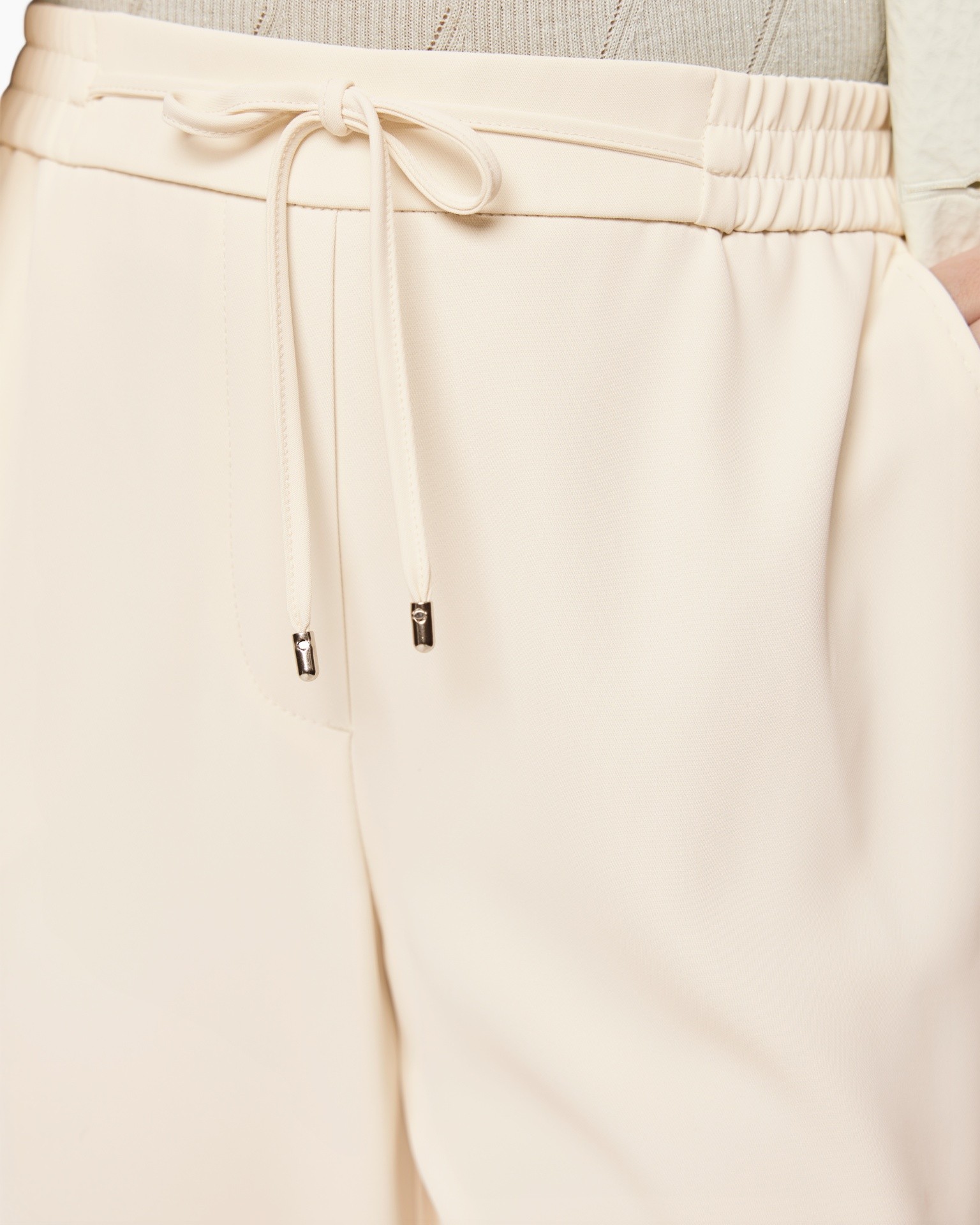 dragstring, taille élastique, pantalon beige, tissu doux, poches inexistantes