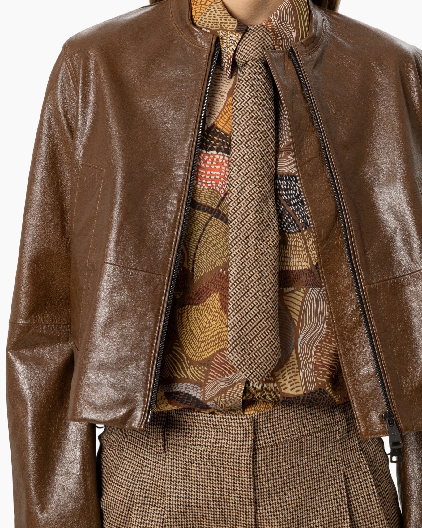 bruin leerjasje, bikerjas, bruine sjaal, geometrische blouse, tweed broek