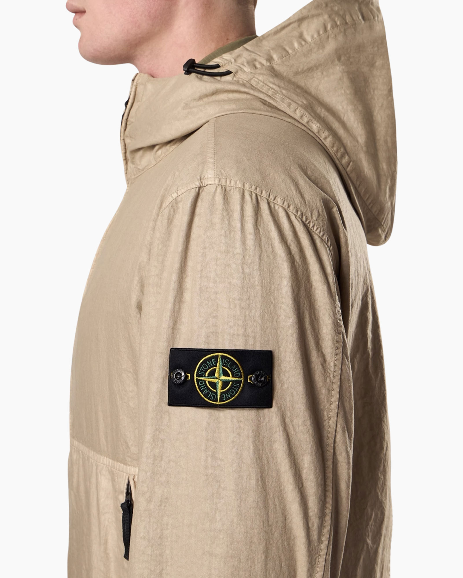 beige jas, hoes, patch, Stone Island (merk zichtbaar), rugszak ritssluiting zak