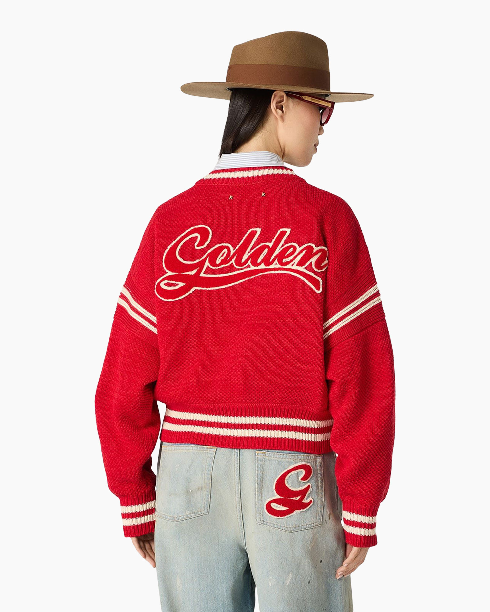 rode trui, rond hals, gestreepte manchetten, versleten jeans, fedora-hoed