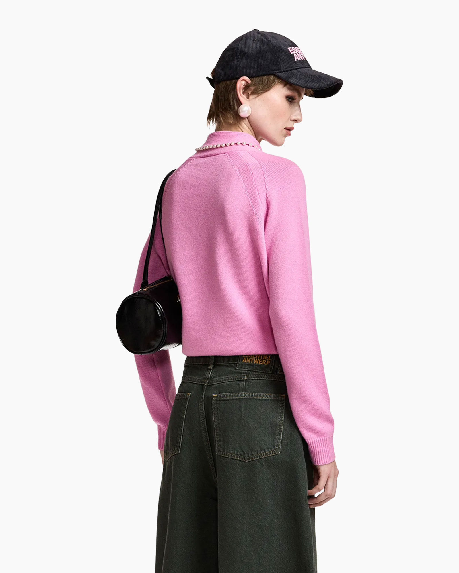 roze trui, brei top, parels sjaal, baseballpet, zwarte handtas