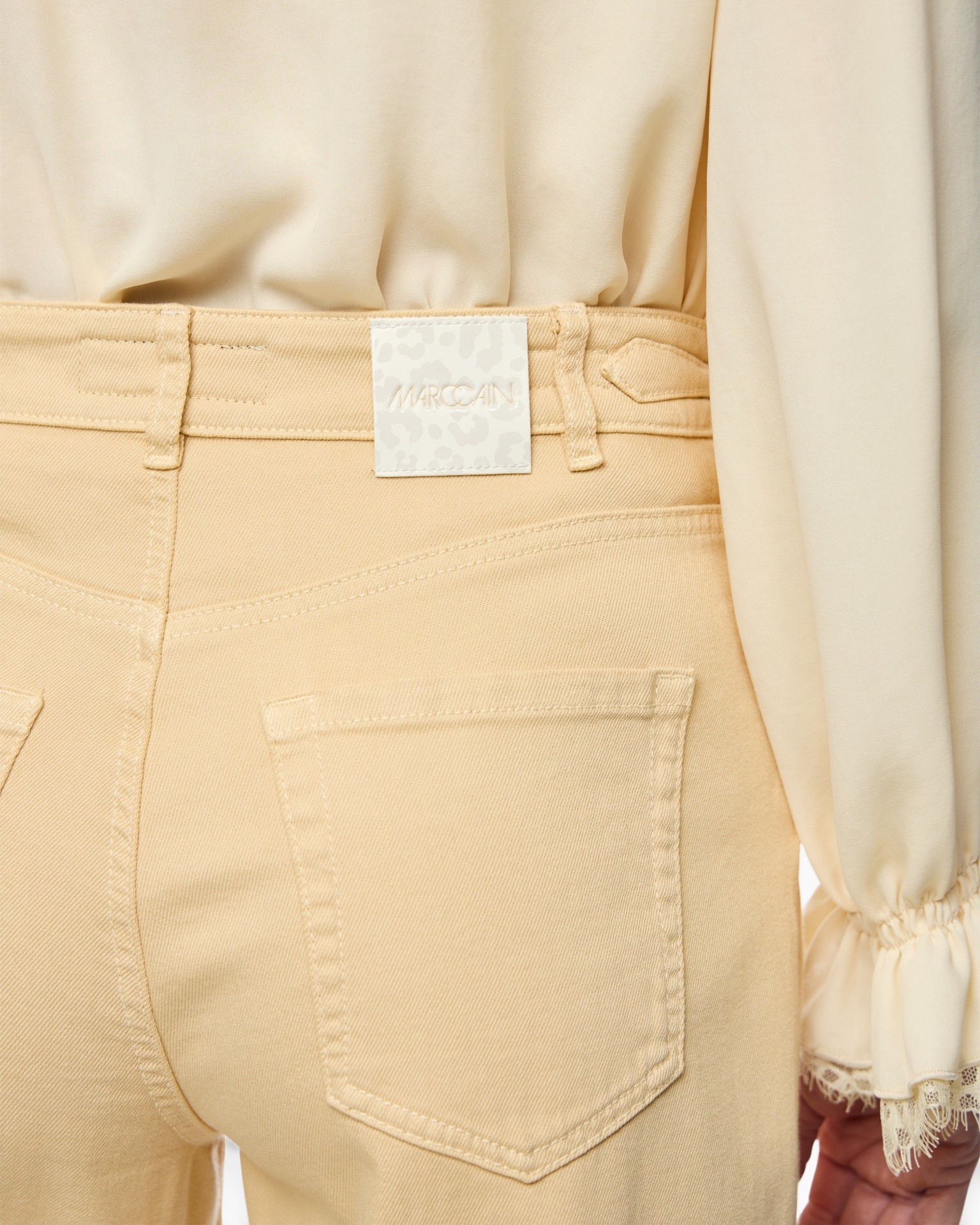 beige broek, rugzakzak?, gordel lus, spijkerstijl, etiket op taille