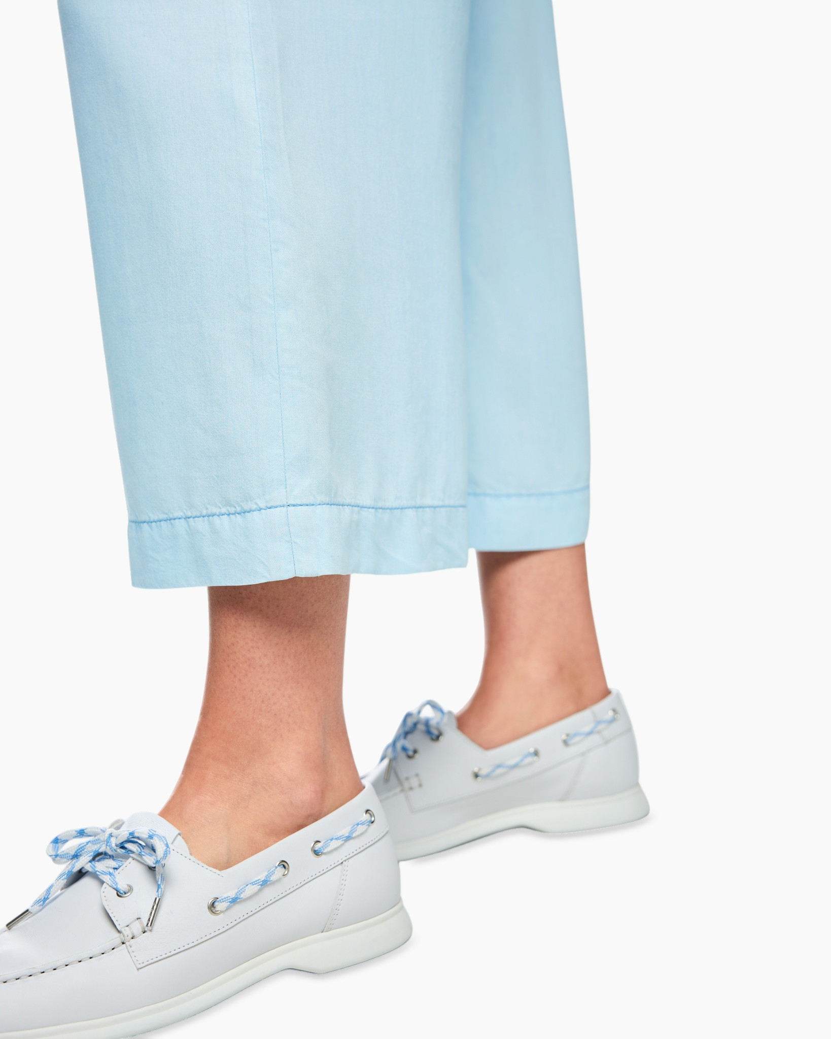 light blue pants, ankle length, linen-like fabric, laced boat shoes, white sneakers