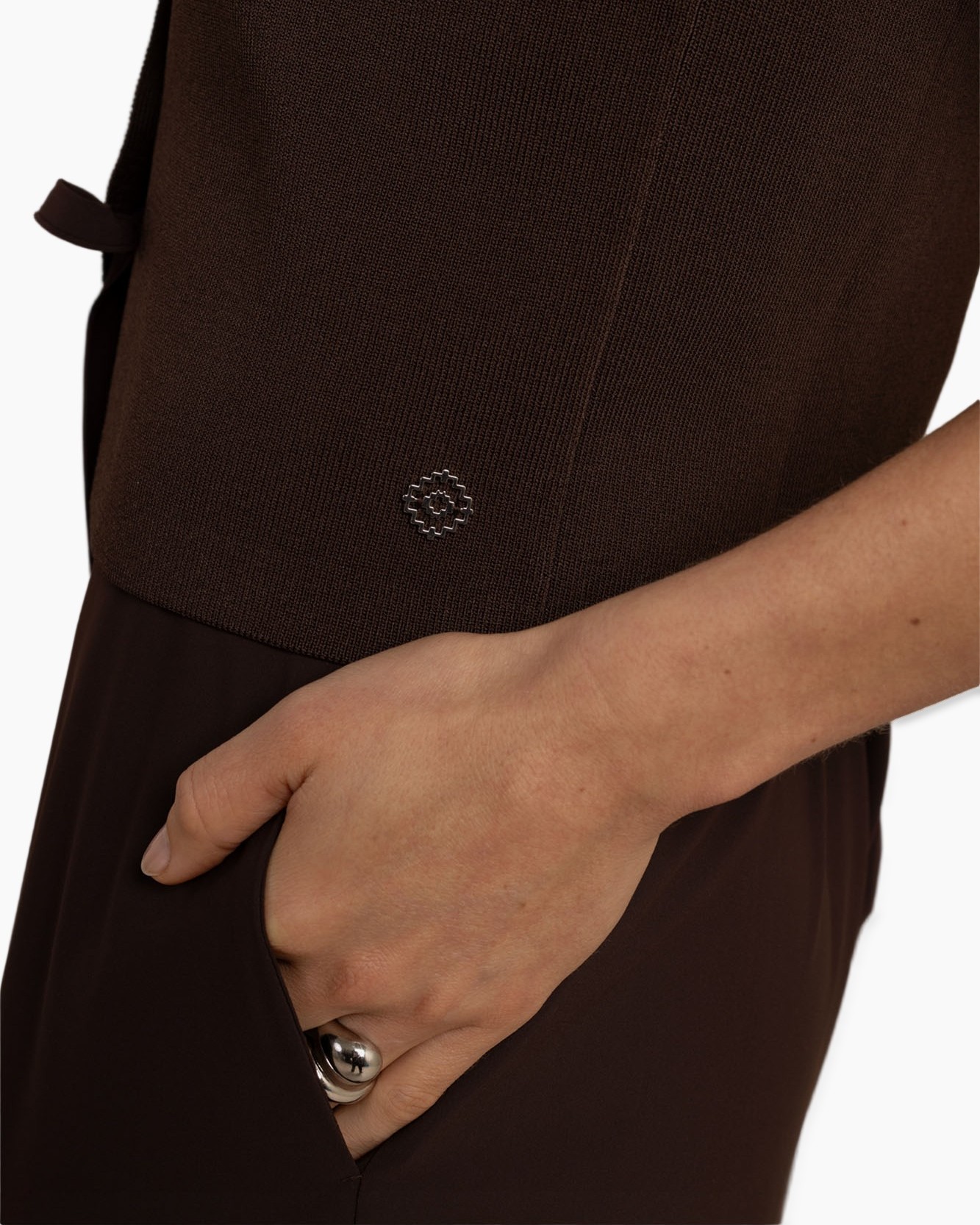 bruine top, brei-stof, metalen embleem, korte mouw, zak detail